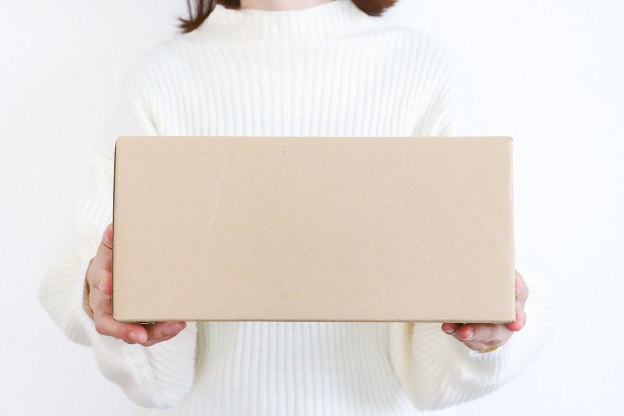 段ボールを持った女性の手元